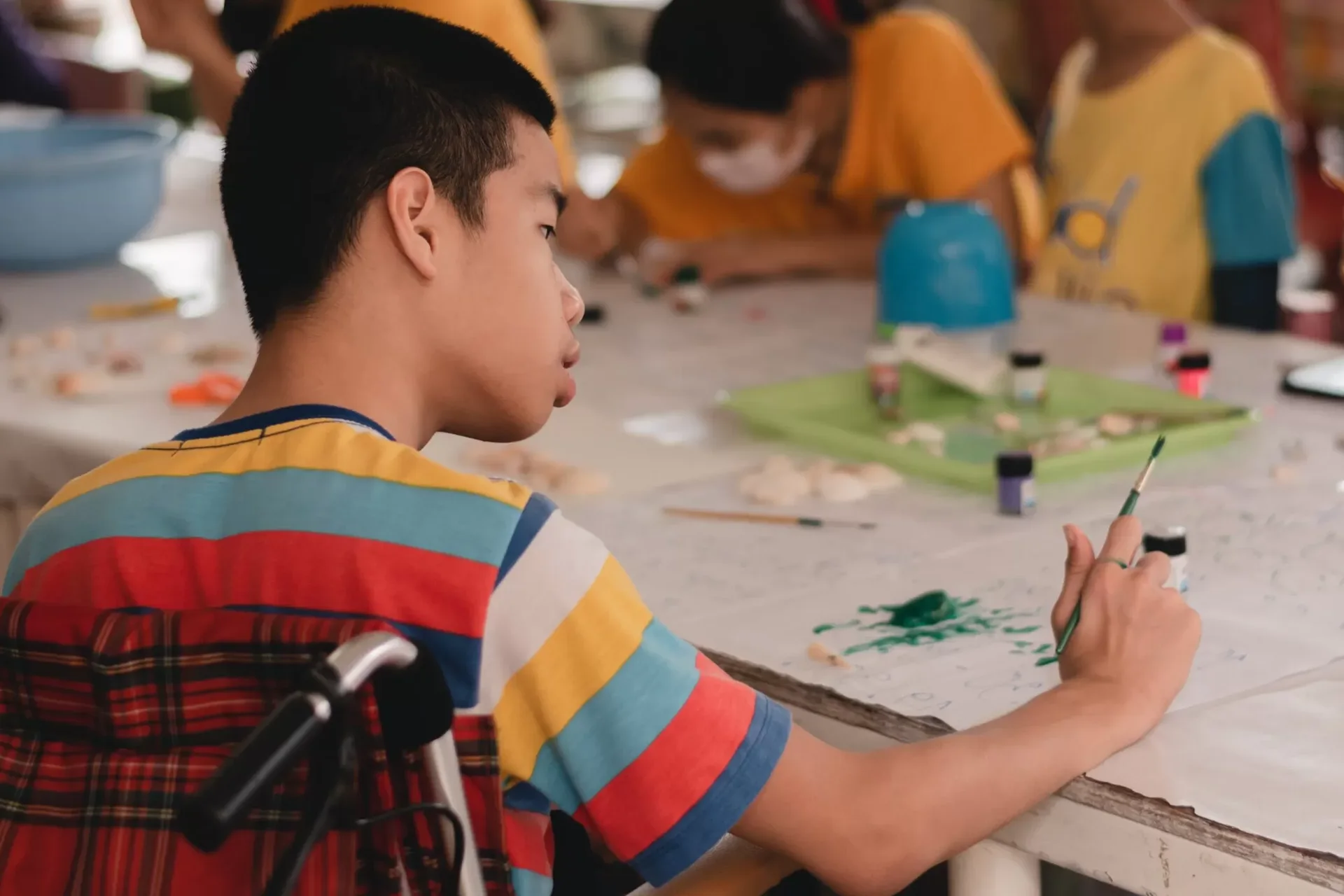 Handicapped boy in a wheelchair painting