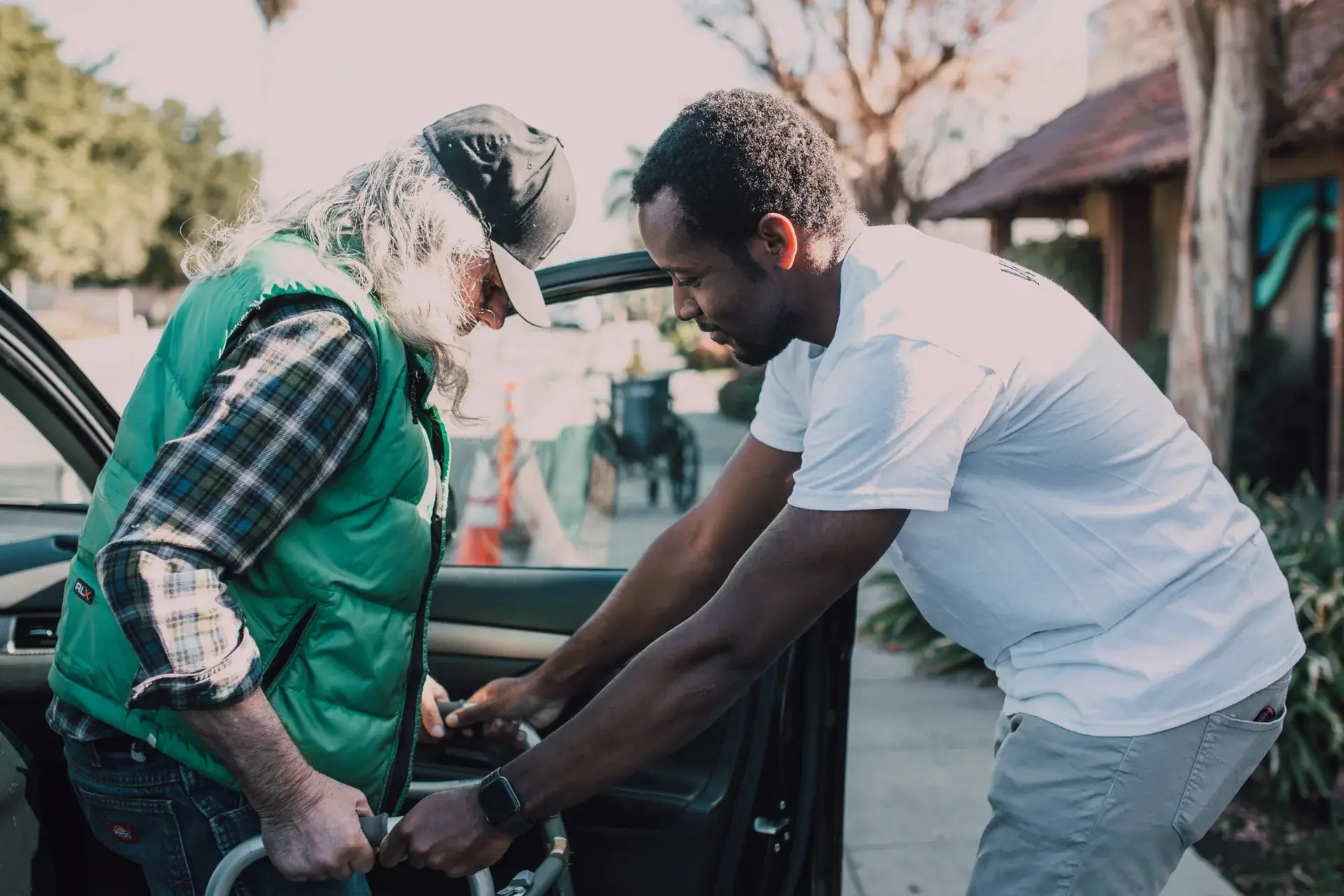 Support worker assisting elderly woman to stand