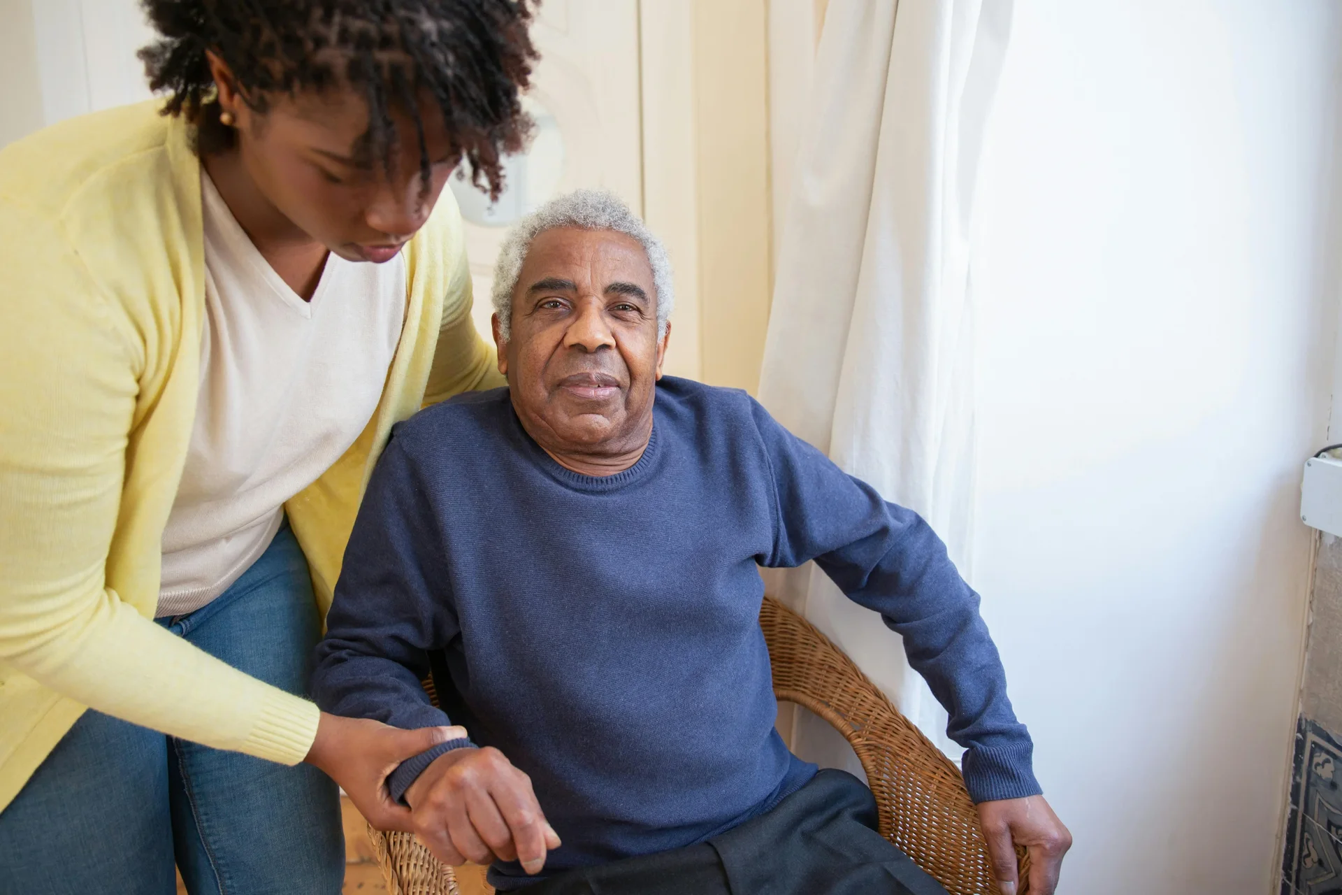 Support worker assisting man in chair