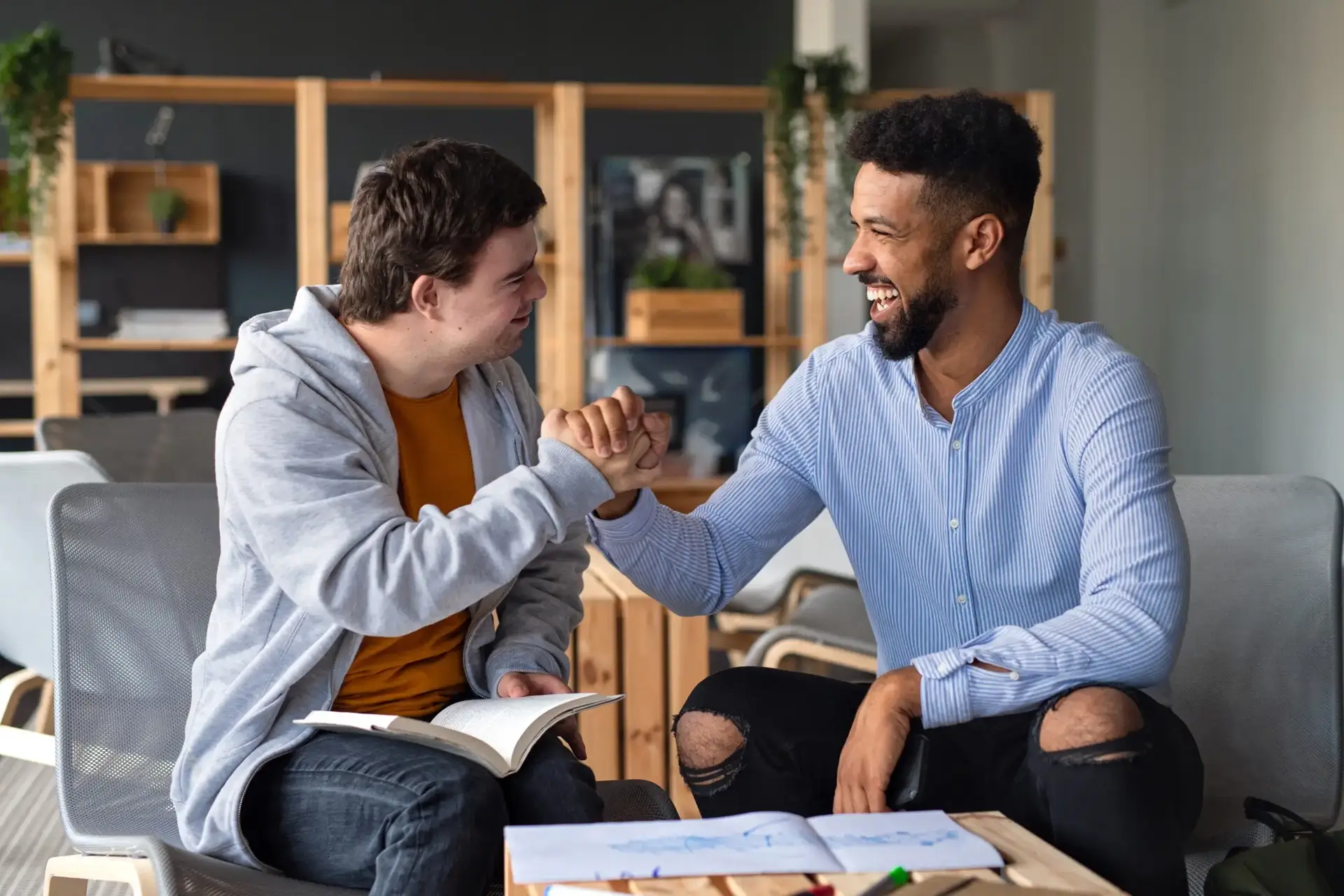 Disable young man having handshake with support worker