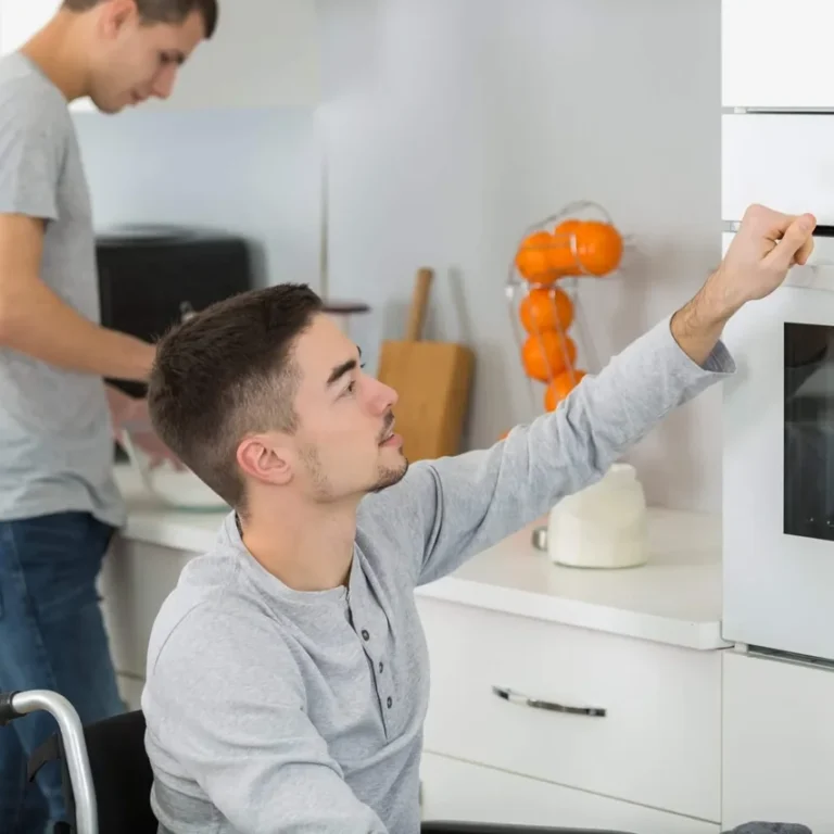 Man in wheelchair in the kitchen with support worker